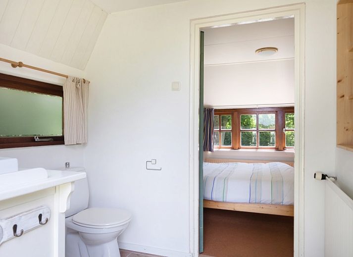 Eetkamer van Meiblok vakantiehuis in Formerum, Terschelling met grote ramen en houten eettafel.