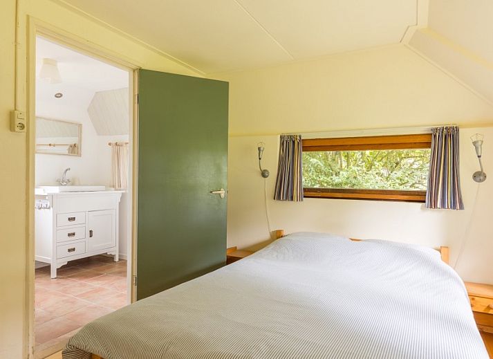 Eetkamer van Meiblok vakantiehuis in Formerum, Terschelling met grote ramen en houten eettafel.