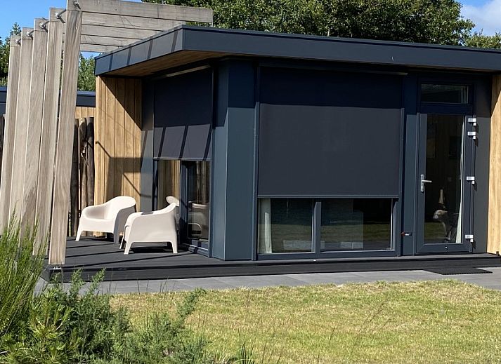 ZONICE chalet in Formerum, Terschelling met moderne uitstraling en terras in groene omgeving.