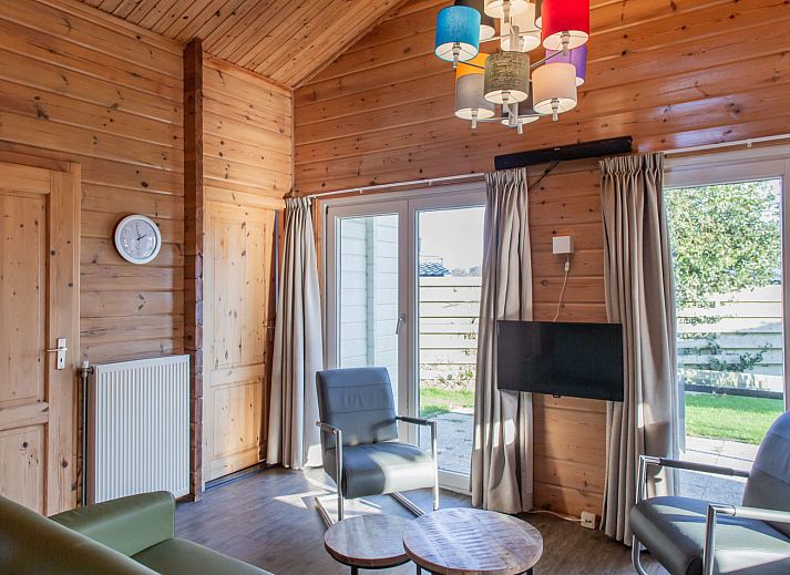 Finnish bungalow 5 persons in Hee, Terschelling with charming wooden facade and bikes in front of the door, ideal for nature lovers.