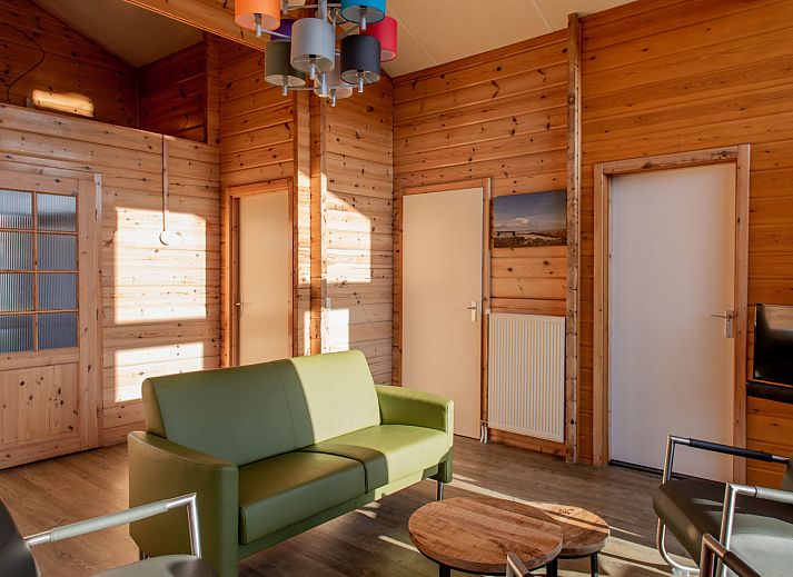 Cozy indoor area of Finnish bungalow 5 persons, Hee, Terschelling, with comfortable seating and lots of natural light.