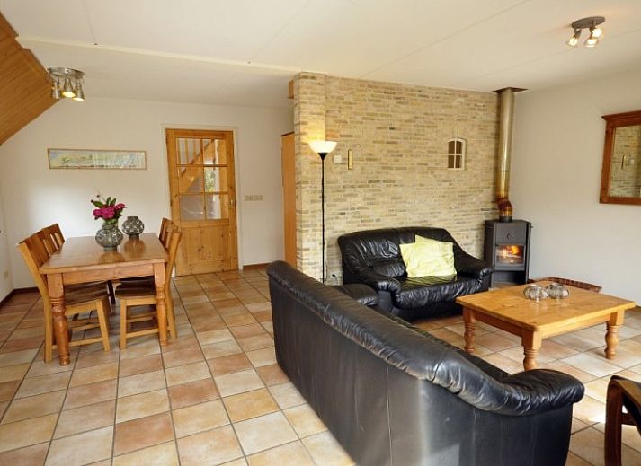 Flaches Bauernhaus de Hek West in Hoorn, Terschelling mit einer einladenden Terrasse und gruener Umgebung.