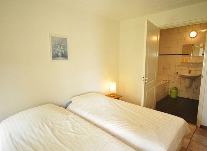 Flaches Bauernhaus de Hek West in Hoorn, Terschelling mit einer einladenden Terrasse und gruener Umgebung.