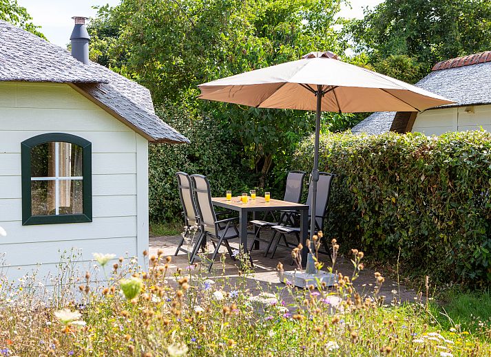 Dining room in Schuttersbos cottage, Midsland, Terschelling with modern kitchen and bright decor.