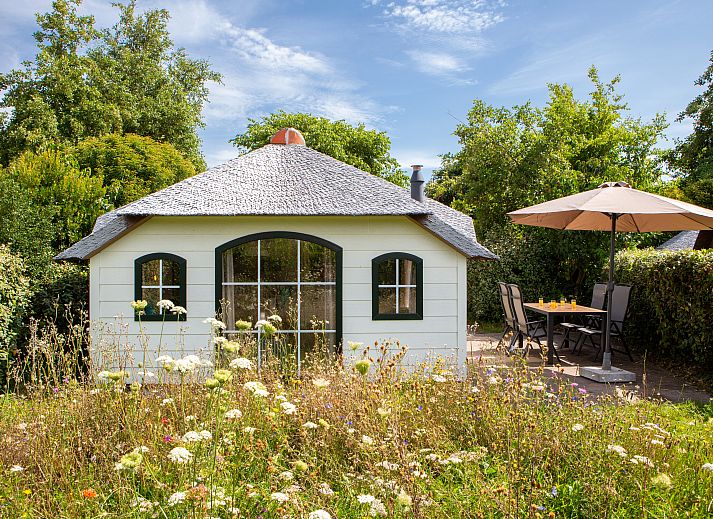 Dining room in Schuttersbos cottage, Midsland, Terschelling with modern kitchen and bright decor.
