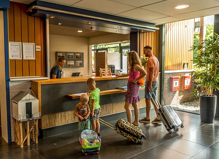 Gezellige woonkamer in Wellness Appartement | 6 Pers in Midsland, Terschelling met comfortabele zithoek en moderne keuken.