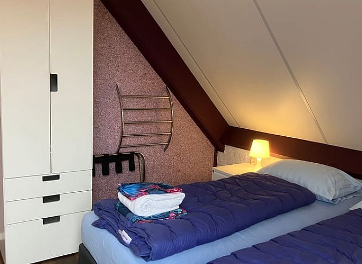 Gemuetliches Aeusseres des Ferienhauses in Oosterend auf Terschelling, mit sonniger Veranda und bunten Blumen.