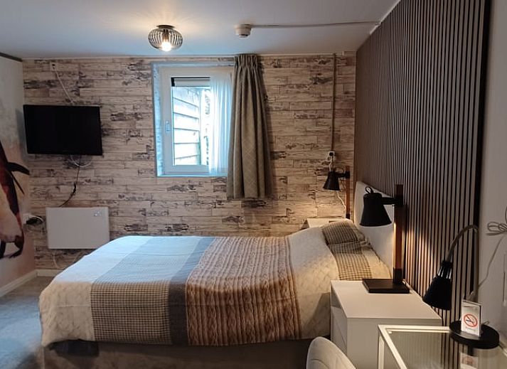 Stijlvolle slaapkamer met bloemenbehang in Huisje in Oosterend, Waddeneilanden.