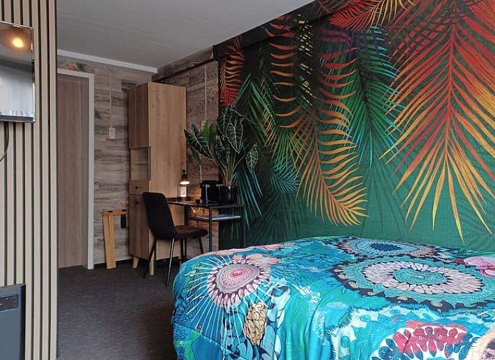 Stijlvolle slaapkamer met bloemenbehang in Huisje in Oosterend, Waddeneilanden.