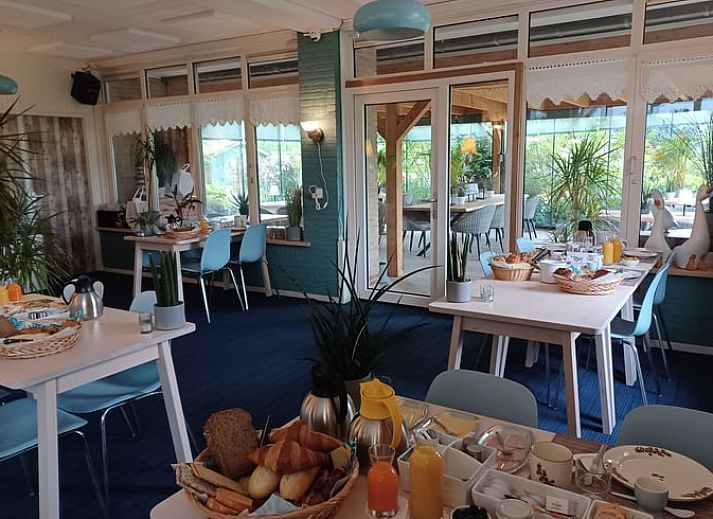 Stijlvolle slaapkamer met bloemenbehang in Huisje in Oosterend, Waddeneilanden.