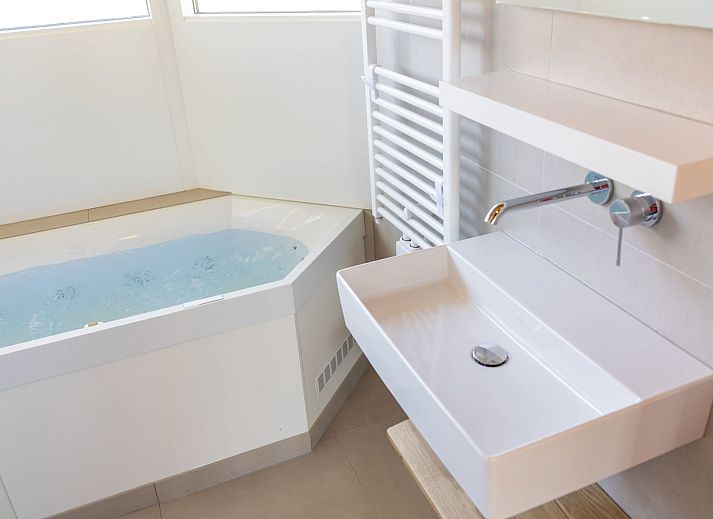 Geniessen Sie die Terrasse der Villa bungalow Whirlpool in Oosterend, Terschelling. Entspannen Sie sich in der gruenen Umgebung dieses Ferienhauses.