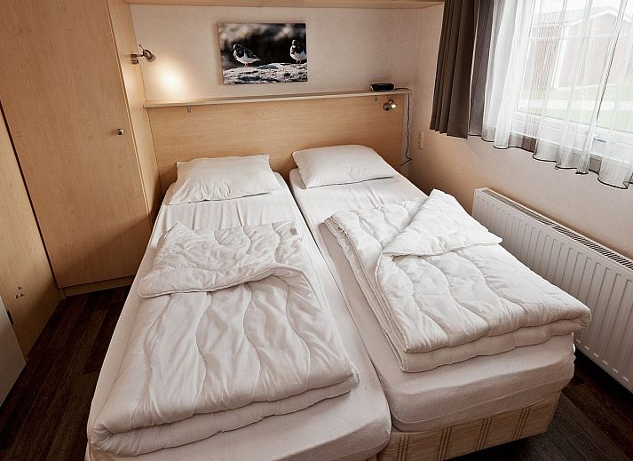 Terrasse von Duinbungalow Tjermelan in Oosterend, Terschelling mit bequemen Gartenstuehlen.