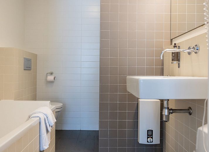 Front view of Apartment Bath Douche in Oosterend, Terschelling with sunny garden and deck chairs.