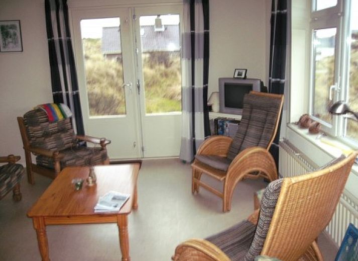 Ferienhaus Pirola in Midsland aan Zee, Terschelling, umgeben von Dnen, auf denen die Wattenmeerflagge weht.