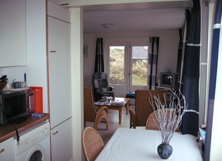 Ferienhaus Pirola in Midsland aan Zee, Terschelling, umgeben von Dnen, auf denen die Wattenmeerflagge weht.