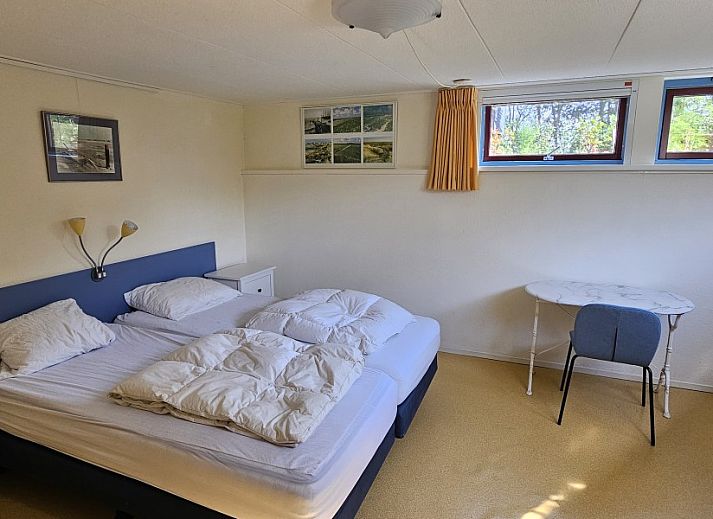 Cozy living room in Glissando bungalow, Midsland Noord, Terschelling with comfortable blue sofa.