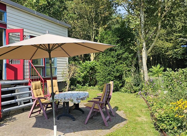 Cozy living room in Glissando bungalow, Midsland Noord, Terschelling with comfortable blue sofa.