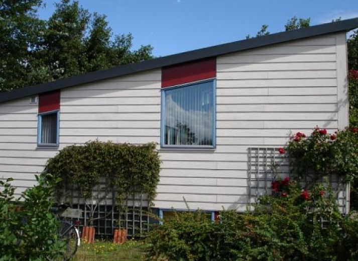 Cozy living room in Glissando bungalow, Midsland Noord, Terschelling with comfortable blue sofa.