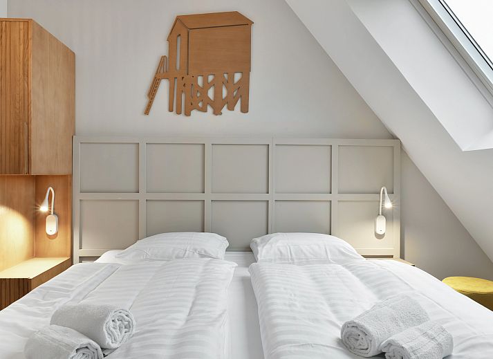 Spacious living room of the 4-person penthouse 4CP in West Terschelling with comfortable sitting area and view of the dunes.