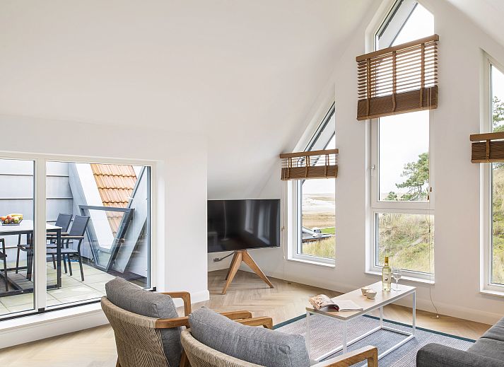 Bright interior space of the 4-person penthouse 4CP in West Terschelling with access to the terrace and views of nature.