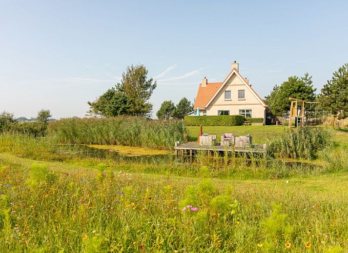 De Dijkwachter in Ballum, Ameland, Ferienhaus am Wasser mit Holzterrasse und schoener Aussicht auf die Natur.