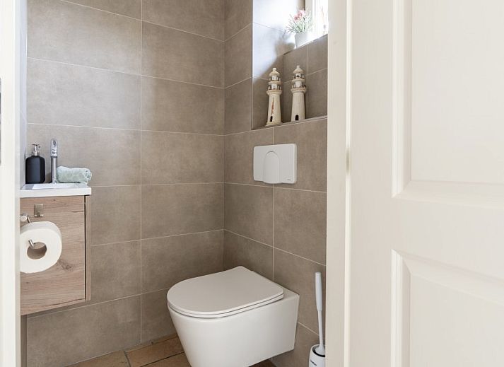 Moderne Kueche im Ferienhaus De Dijkwachter, Ballum, Ameland, mit Holzverkleidung und allen Annehmlichkeiten.