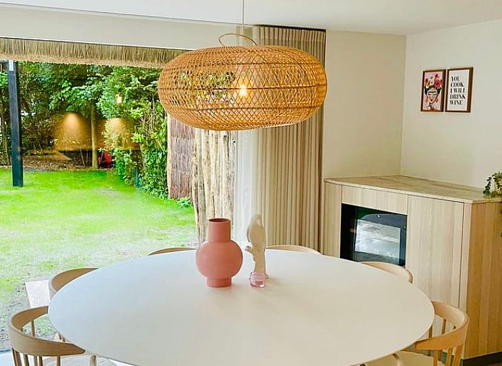Charmant vakantiehuisje in Ballum met rieten dak, Ameland, omgeven door groen.
