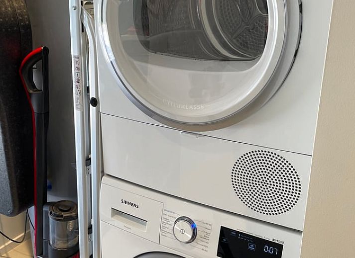 Verlichte buitenkant van vakantiehuisje in Ballum, Ameland bij schemering.