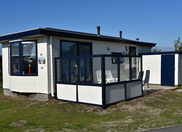 Gezellige woonkamer in chalet Oester 167, Ballum, Ameland met veel natuurlijk licht en comfortabele zitplaatsen.