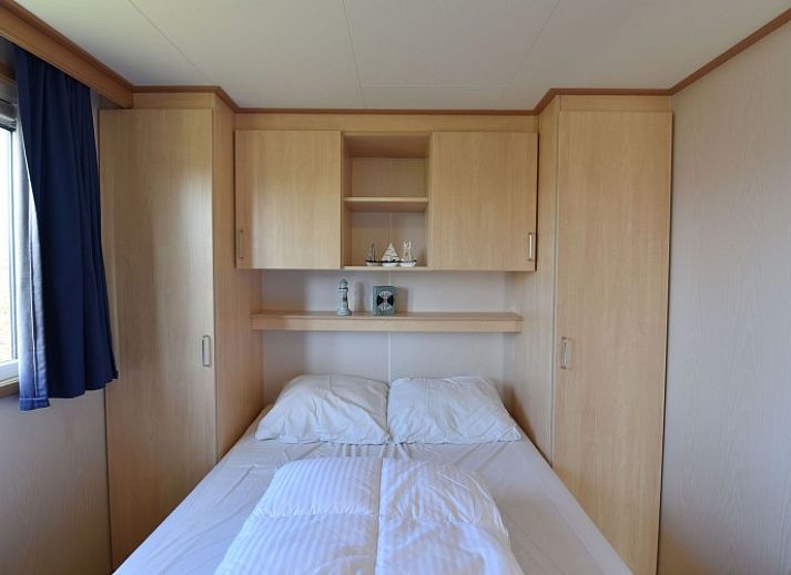 Gezellige woonkamer in chalet Oester 167, Ballum, Ameland met veel natuurlijk licht en comfortabele zitplaatsen.