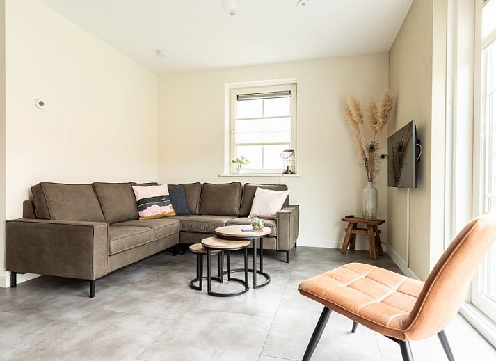 Gezellige woonkamer in Storm Ameland appartement, Ballum, met comfortabele zitruimte.