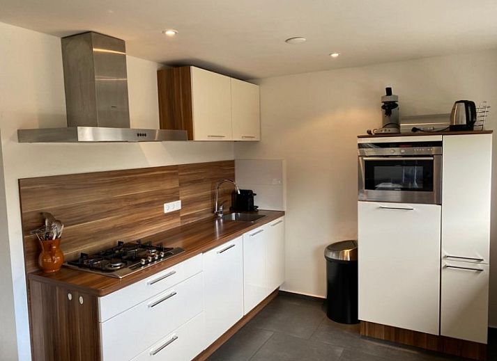 Cozy living room of Tree Lodge in Ballum, Ameland with comfortable sofas and wood stove.