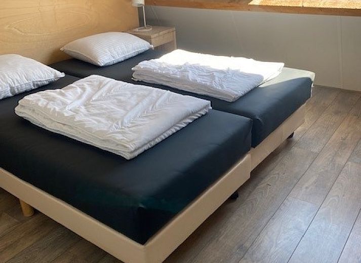 Modern sitting area in Tree Lodge, Ballum, Ameland with spacious sofas and television.