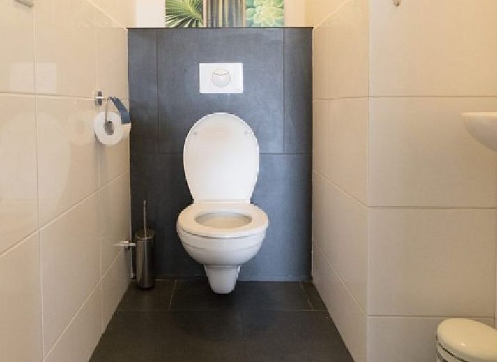 Modern sitting area in Tree Lodge, Ballum, Ameland with spacious sofas and television.