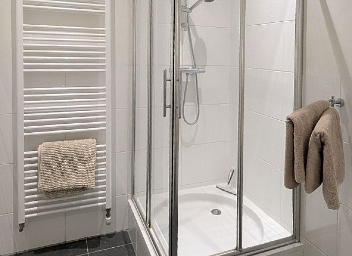 Stijlvolle woonkamer van Petit appartement in Ballum, Ameland, met leren banken en uitzicht op de natuur.