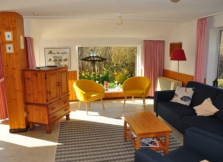 Brockjiske Bungalow in Ballum, Ameland, mit bunten Fahnen und Fruehlingsblumen.