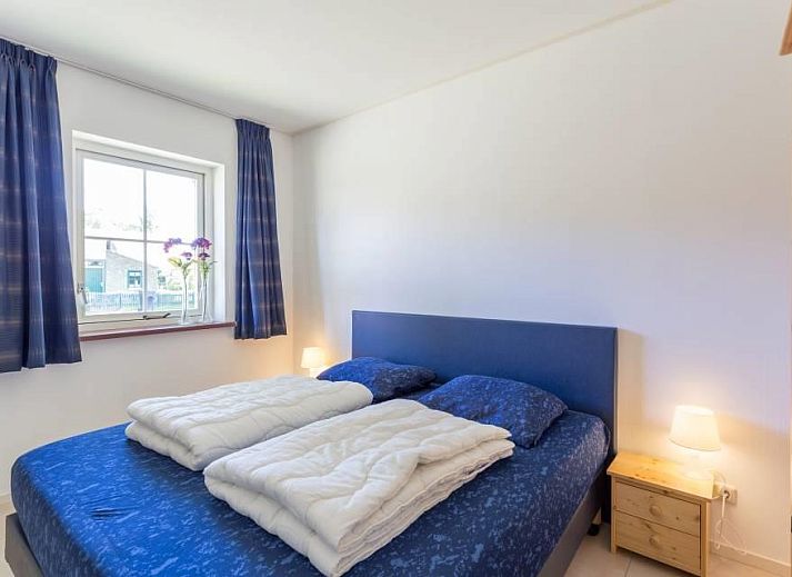 Rustieke buitenkant van vakantiehuis Linde in Ballum, Ameland omgeven door bomen op de Waddeneilanden.