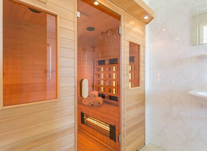 Rustieke buitenkant van vakantiehuis Linde in Ballum, Ameland omgeven door bomen op de Waddeneilanden.