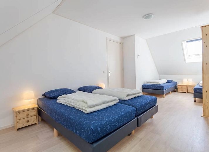 Rustieke buitenkant van vakantiehuis Linde in Ballum, Ameland omgeven door bomen op de Waddeneilanden.