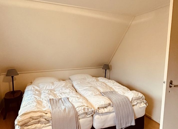 Bloeiende hortensia's bij raam van Akkerduin vakantiehuis in Ballum, Ameland.