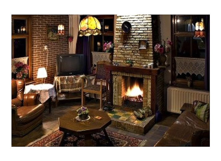 Ferienhaus Suzan in Ballum, Ameland mit charmanter roter Eingangstuer und gruenem Garten.