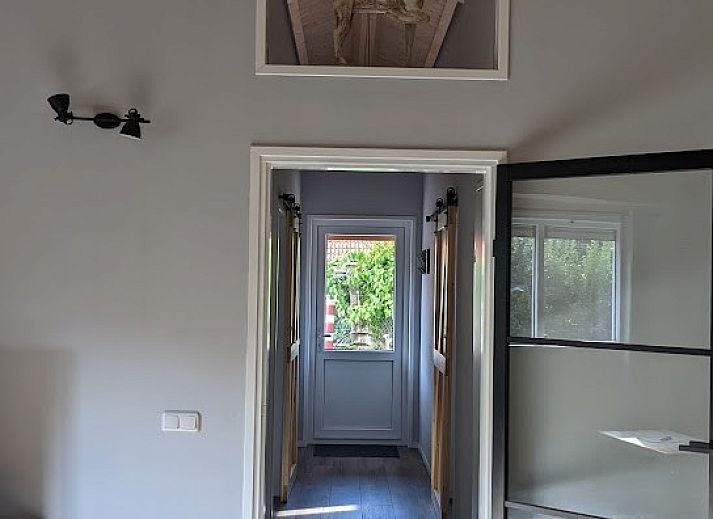 Gezellige eetruimte in bungalow Duunke, Ballum, Ameland met houten balkenplafond.