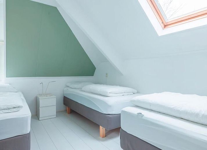 Stijlvolle woonkamer in Noorderzon, Buren, Ameland met kunst aan de muur en comfortabele zitplekken.