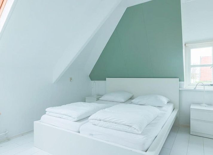 Stijlvolle woonkamer in Noorderzon, Buren, Ameland met kunst aan de muur en comfortabele zitplekken.