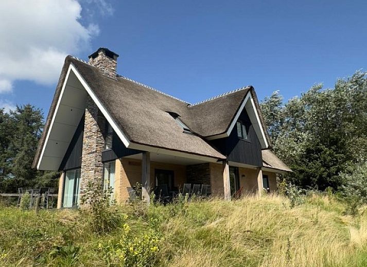 Vakantiehuis MIEKIE in Buren, Ameland omgeven door groene natuur en blauwe lucht.