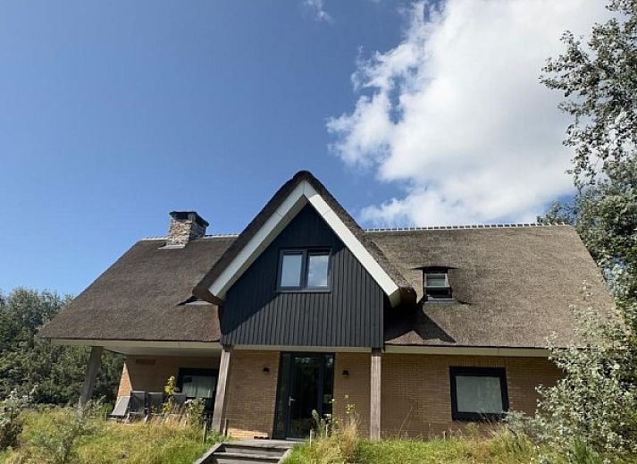 Vakantiehuis MIEKIE in Buren, Ameland omgeven door groene natuur en blauwe lucht.