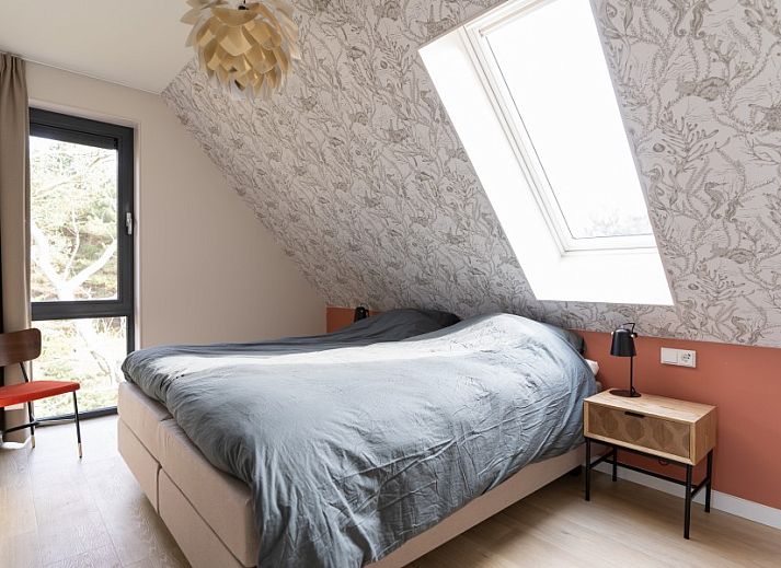 Rieten dak van vakantiehuis MIEKIE in Buren, Ameland, omgeven door gras en bomen.