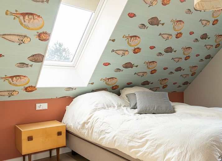 Rieten dak van vakantiehuis MIEKIE in Buren, Ameland, omgeven door gras en bomen.