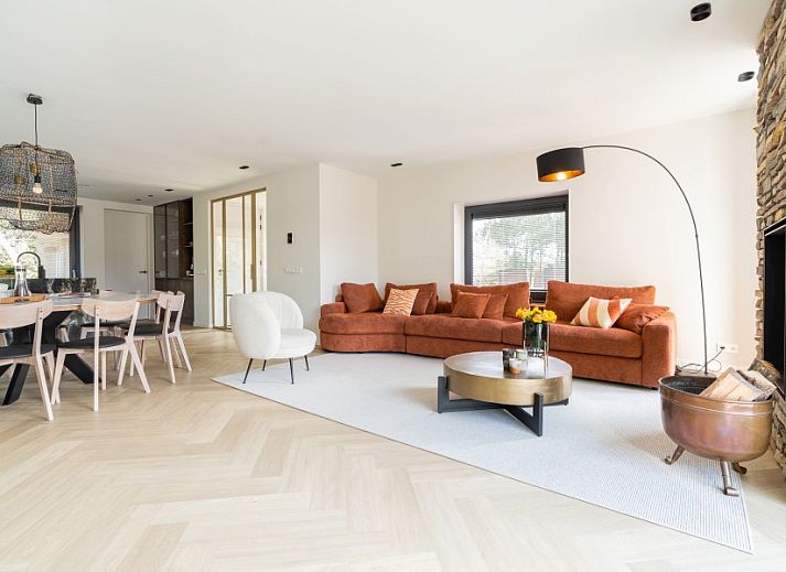 Hoofdingang van vakantiehuis MIEKIE in Buren, Ameland met houten trap en groene omgeving.