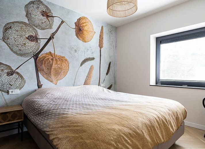 Hoofdingang van vakantiehuis MIEKIE in Buren, Ameland met houten trap en groene omgeving.